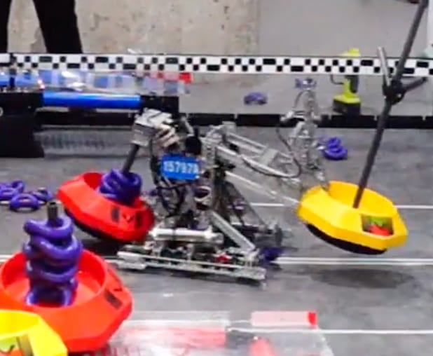 The 15797A Tipping Point robot carrying a goal on the field